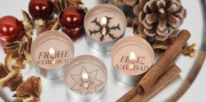 Vier Teelichter mit weihnachtlichen Botschaften und weihnachtlicher Deko
