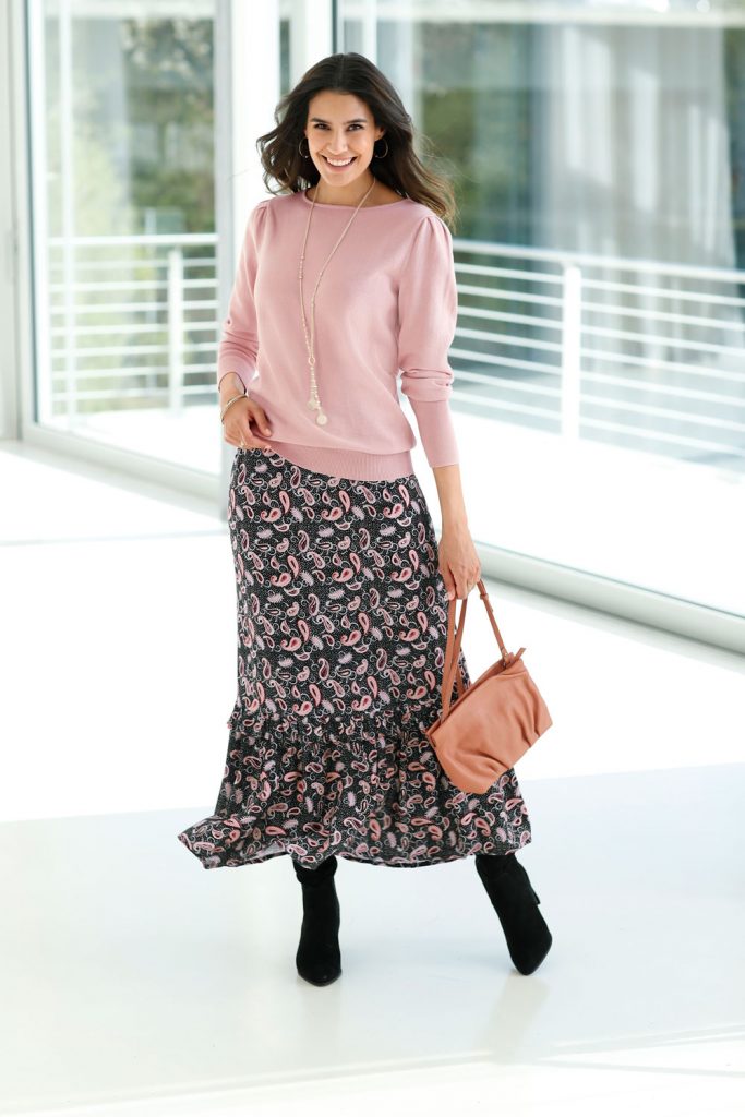 Frau mit Rock in Paisleymuster und rosa Oberteil